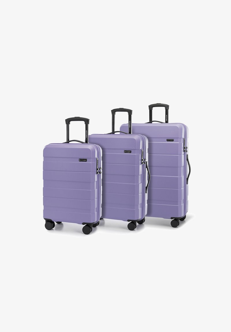 Drei Hartschalenkoffer in hellem Lavendel mit geriffeltem Design, schwarzen Rollen und ausziehbaren Griffen.