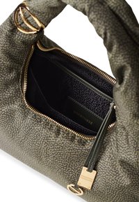 Olive green handbag with a textured pattern, gold hardware, a zip closure, and a dark interior featuring a slip pocket with branding.