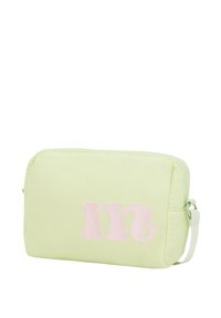 Bolsa de tela acolchada de color verde claro con cierre de cremallera. Presenta una letra "m" bordada en rosa en el frente y una correa ajustable.