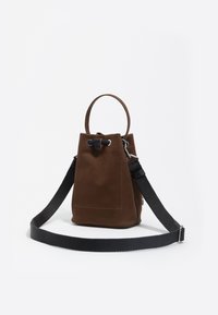 Hnedá semišová kabelka v tvare vedra s okrúhlym držadlom, nastaviteľným čiernym popruhom, zaisťovacím sťahovacím uzáverom a detailom prednej vrecka.