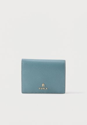 Gefaltete petrolfarbene Lederbrieftasche mit goldenem Furla-Logo mittig vorne vor einfarbigem weißem Hintergrund.