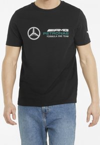 Mustat puuvillateepaidat, joissa on valkoinen Mercedes-logo ja "AMG PETRONAS FORMULA ONE TEAM" turkoosilla. Lyhythihainen malli ja pyöreä kaula-auko.