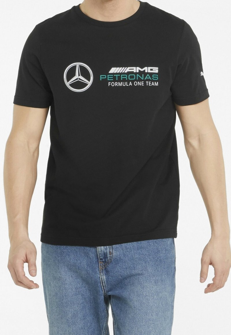 Mustat puuvillateepaidat, joissa on valkoinen Mercedes-logo ja "AMG PETRONAS FORMULA ONE TEAM" turkoosilla. Lyhythihainen malli ja pyöreä kaula-auko.