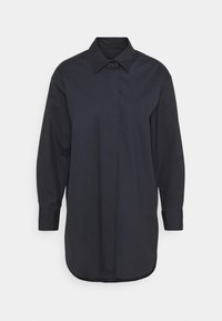 Mörkblå knapp-down skjorta med lång ärm, en traditionell krage och en lätt rundad nederkant. Tillverkad av ett mjukt tyg med en skräddarsydd passform.