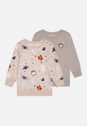 Dvě dlouhé mikiny s dlouhým rukávem z měkké bavlny. První je béžová s barevnými tisky na téma Halloweenu; druhá je jednobarevná šedá s malým designem.