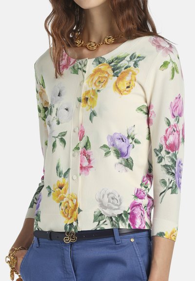 Krém színű virágos kardigán sárga, rózsaszín, lila és fehér rózsákkal. Puha kötött anyag, gombos záródás és háromnegyedes ujjú.