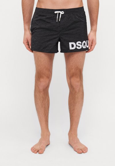 Schwarze Badeshorts mit einer strukturierten Musterung und einem auffälligen weißen "DSQUARED2"-Logo an der Seite. Elastischer Bund mit Kordelzug.