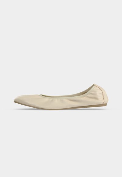 Ballerine beige en cuir souple avec bout arrondi, profil latéral bas et semelle fine en caoutchouc sur fond blanc uni.