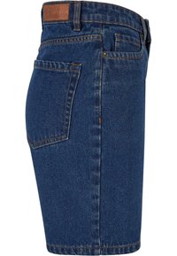 Jupe en jean denim bleue avec poche arrière, passants pour ceinture et un patch en cuir marron sur la ceinture.