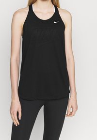 Débardeur noir Nike avec un design dos nageur, tissu léger et un logo discret sur le devant. Associé à un legging noir.