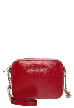 Pequeño bolso bandolera rectangular de cuero rojo brillante con correa de cadena dorada y logo dorado de Michael Kors en el frente.