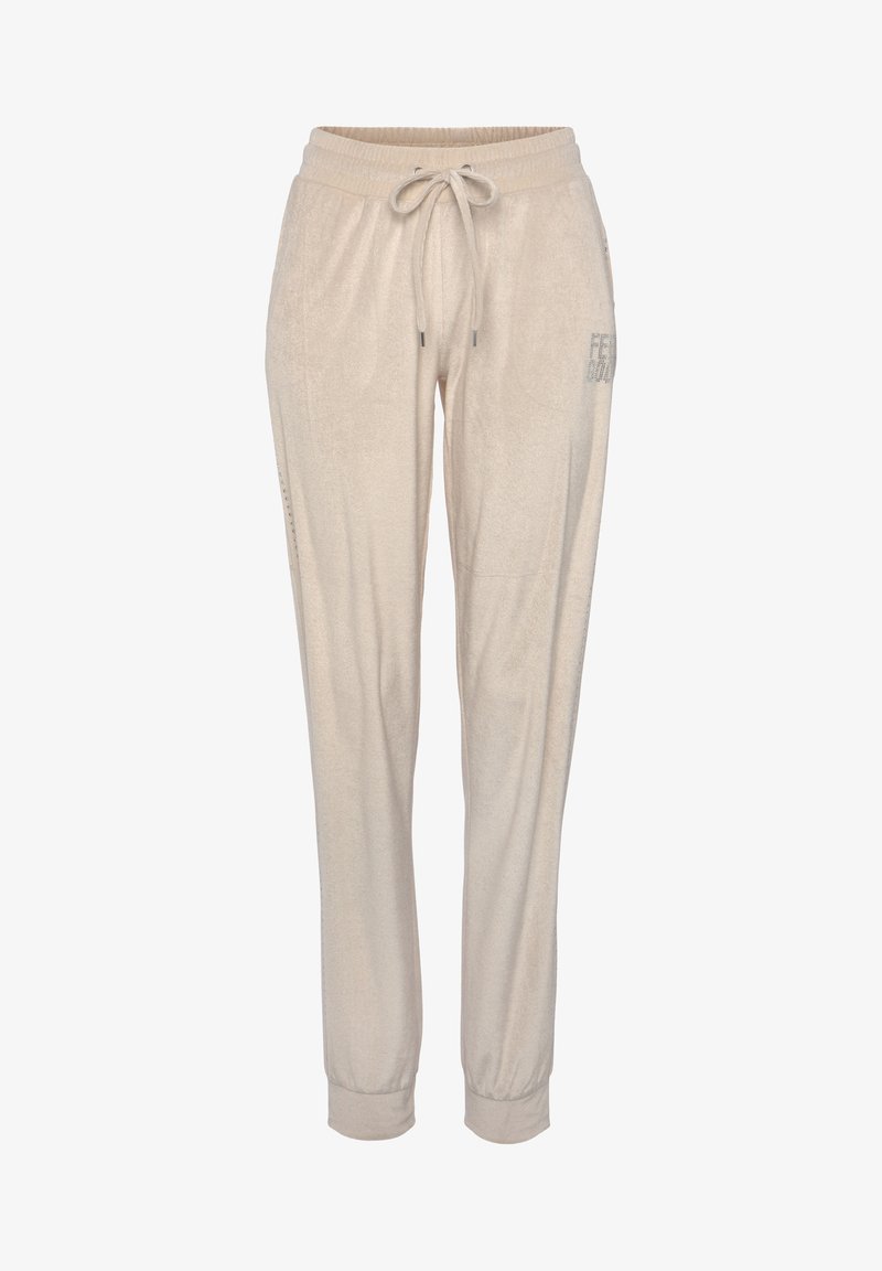 Lichtbeige joggers met een zachte textuur, elastische tailleband en verstelbare trekkoord. Voorzien van zijzakken en een subtiele print op één been.
