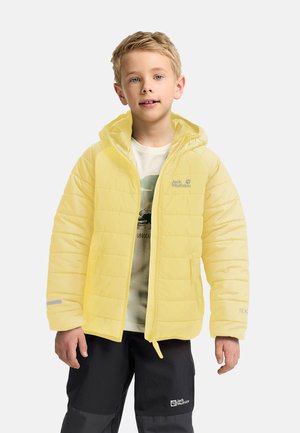 Gelbe gepolsterte Jacke mit Kapuze, ausgestattet mit einem Reißverschluss auf der Vorderseite, einem Logo auf der Brust und reflektierenden Akzenten. Getragen über einem leichten Hemd und dunklen Hosen.
