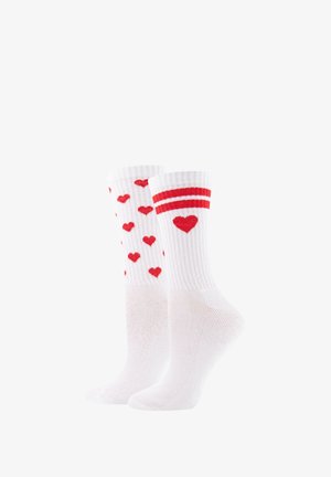 Paar weiße Knöchelsocken mit roten Herzmustern, eines mit mehreren kleinen Herzen und das andere mit einem Herz und zwei roten Streifen.