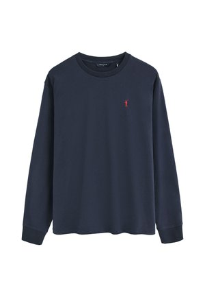 Granatowy longsleeve z okrągłym dekoltem i małym czerwonym logo zawodnika polo na lewej piersi.