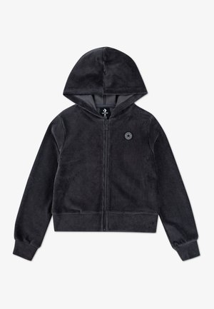 Veste noire zippée à capuche, manches longues et poignets côtelés, avec un petit logo rond sur le côté gauche de la poitrine.