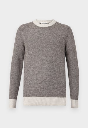 Pull rayé gris et crème, avec un col rond côtelé et des poignets. Texture douce avec des rayures horizontales, présentant une coupe décontractée.