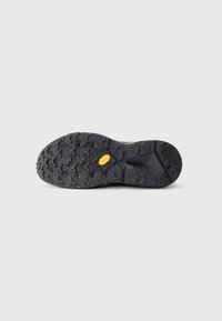 Talpa de pantof din cauciuc Vibram negru, cu modele de adâncime și logo-ul Vibram galben în centrul său, pe un fundal alb simplu.