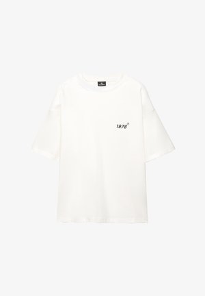 Bela oversized majica iz mehkega bombaža, z kratkimi rokavi in majhnim črnim tiskanim logotipom "1978" na levi strani.