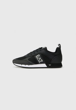 Black athletic shoes with mesh and synthetic upper, white accents, textured rubber sole, and logo detailing on the side.