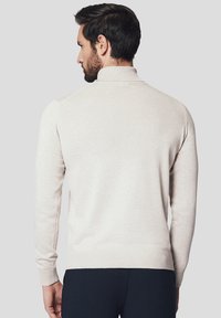 Sweter w kolorze kremowym z wysokim kołnierzem, długimi rękawami oraz prążkowanymi mankietami i dołem. Miękka tekstura z delikatnymi detalami dzianiny.