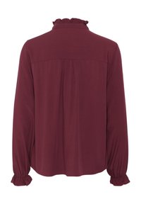 Burgundy long-sleeve blouse with a ruffled collar, gathered shoulders, and elasticated cuffs, featuring a smooth, lightweight fabric.