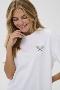 Weißes Baumwoll-T-Shirt mit einem kleinen grünen Tennisschläger-Print auf der linken Brust. Kurze Ärmel und lockere Passform. Glatte Textur.