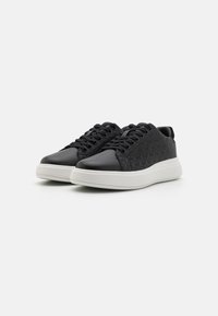 Sneaker nere con una parte superiore testurizzata caratterizzata da un motivo sottile, punta arrotondata, chiusura con lacci e suola in gomma bianca.