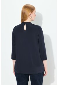 Laadukkaasta pehmeästä kankaasta valmistettu laivastonsininen pitkähihainen paita, jossa on avainaukko selkäpuolella. Ominaisuuksiin kuuluu rento istuvuus ja pyöreä pääntie.