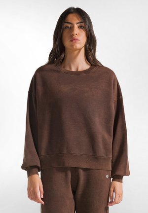 Bruine oversized sweatshirt gemaakt van zachte stof met een gestructureerde uitstraling, met een ronde halslijn en een ontspannen pasvorm.
