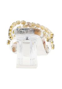 Sandale à talon haut transparente avec un talon chunky, ornée d'accents en perles jaunes et dorées, présentant une semelle intérieure décorative à motifs.