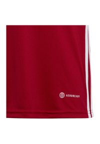 Jersey deportivo rojo con una textura suave, rayas laterales blancas y el logo "AEROREADY" en el dobladillo. Diseño de ajuste estándar y ligero.