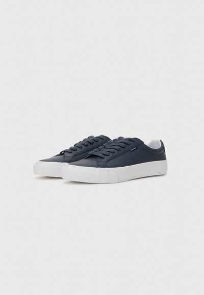Navy blue sneakers with a smooth leather upper and white rubber sole. Features flat laces and minimal branding on the side.
