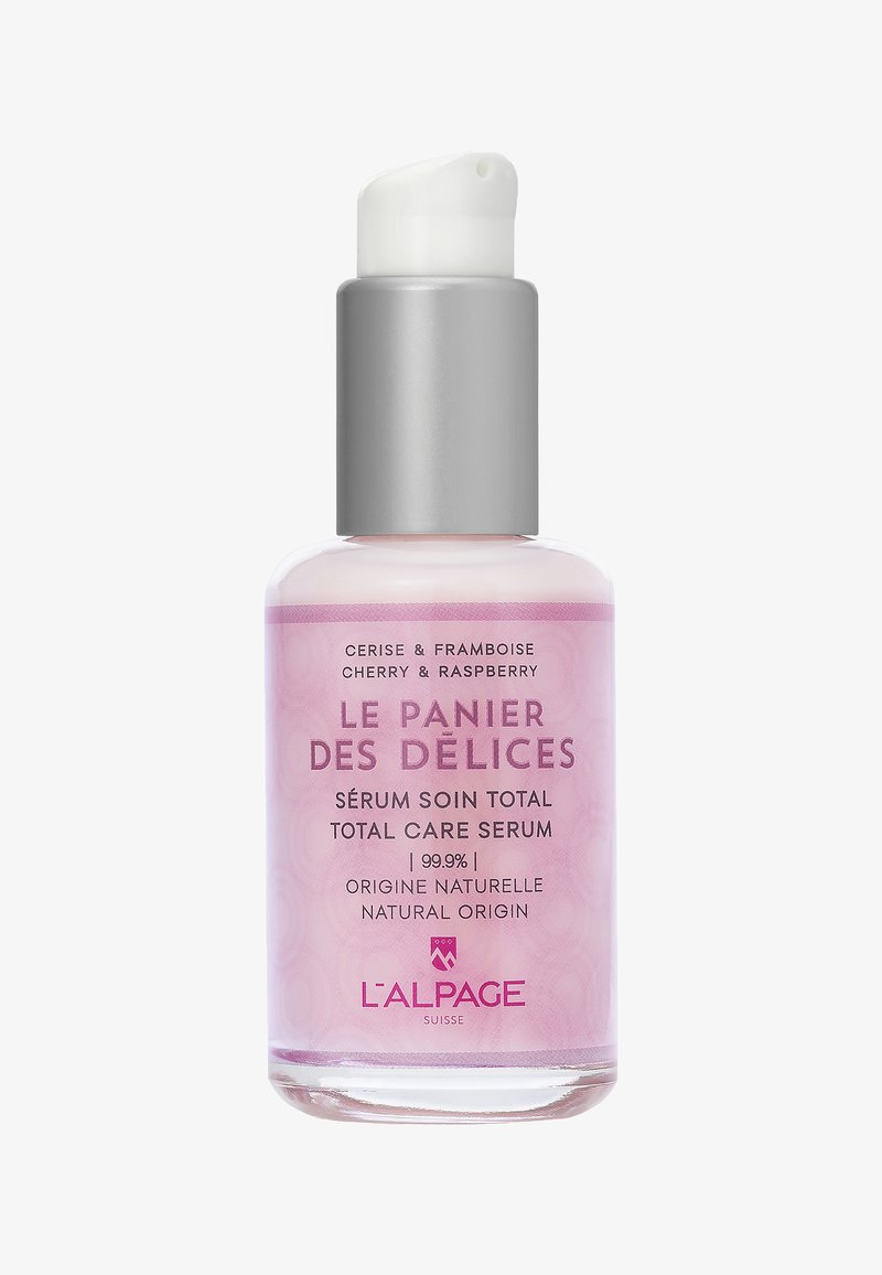 Flacone di siero in vetro rosa con pompa superiore argentata. L'etichetta mostra il nome del prodotto, gli ingredienti e "99,9% origine naturale" in un carattere elegante.