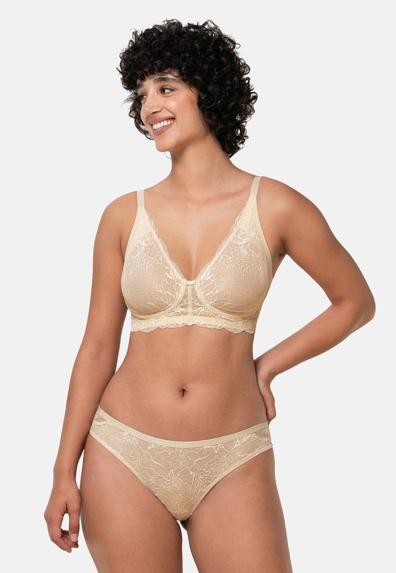 Blonde blonder bralette og matchende trusser i en blød beige tone med blomsterprint, justerbare stropper og bølget kant langs kanterne.