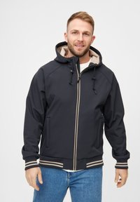 Veste coupe-vent marine avec un intérieur beige, fermeture éclair, cordons de serrage réglables et poignets à rayures côtelées. Deux poches avant sont présentes.