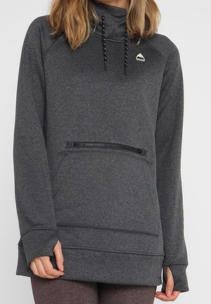 Kobieta w ciemnoszarej bluzie z kapturem typu pulower, z przednią kieszenią na zamek i czarnymi sznurkami, widoczna od ramion do bioder.