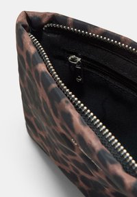 Bagno cosmetico foderato con un design leopardato marrone e nero, dotato di una cerniera argentata e di una tasca interna con zip per organizzazione.