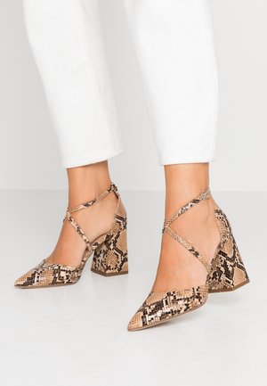 Spidse hæle i en beige og brun slangeskindsprint, med krydskrydsede stropper og en chunky hæl med en tekstureret overflade.