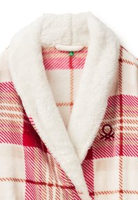 Pluszowy szlafrok z białym, puszystym kołnierzem i czerwonym wzorem w kratę z pomarańczowymi akcentami, w tym małym haftowanym logo na przodzie.