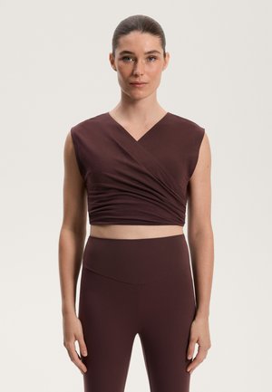 Bordó, rövid ujjú, körbeöltött top, amelyhez azonos színű és sima textúrájú, magas derekú leggings tartozik.