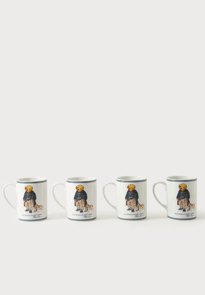 Quatre mugs blancs avec une anse, chacun présentant un ours portant une veste bleu marine et un pantalon beige, debout à côté d'un petit chien, alignés sur une surface blanche.