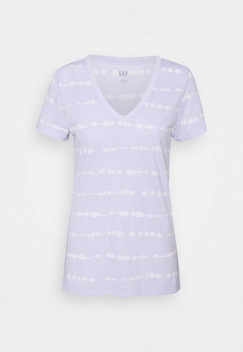 T-shirt lavande clair avec un col en V, présentant un motif tie-dye blanc. Manches courtes et texture en coton douce.