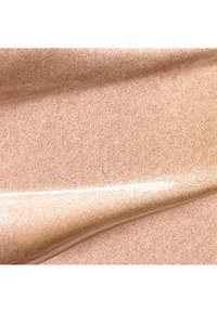 Glat, skinnende champagnefarvet væske med blank tekstur, jævnt fordelt i bløde, flydende lag.