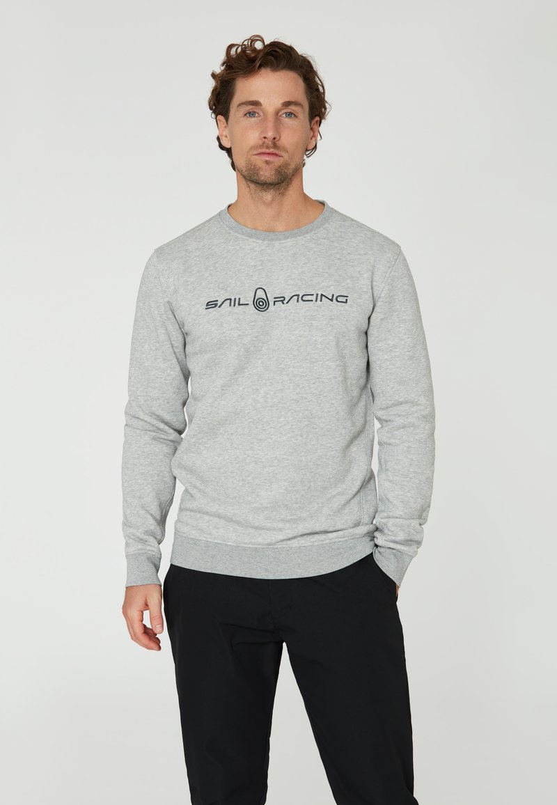 Sudadera gris hecha de una mezcla de algodón, con cuello redondo y puños acanalados. Logo "SAIL RACING" en negro en el pecho.