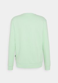 Sudadera verde menta con cuello redondo, mangas largas y puños de canalé. Textura suave, sin patrones, diseño sencillo sin marca visible.