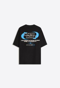 Čierne tričko s krátkym rukávom s modrými kruhovými šípkami a výrazným textom "WHITE NOISE" a citátom o pokoji a ovládnutí hluku na zadnej strane.