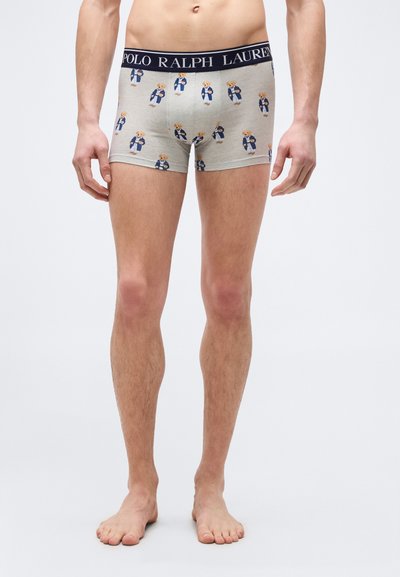 Άνδρας μοντέλο που φοράει ανοιχτό γκρι μποξεράκια με στάμπα αρκουδάκι και ναυτικό μπλε ζωνάρι μέσης με την ετικέτα "Polo Ralph Lauren".