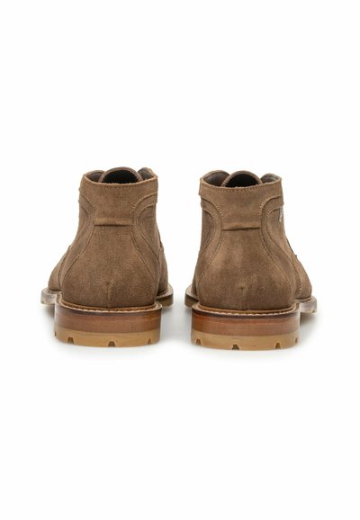 Pair of brown suede ankle boots shown from the back, featuring stitched detailing and stacked wooden soles with rubber treads.