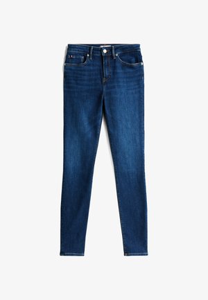 Donkerblauwe skinny jeans met knopen aan de voorkant, ritssluiting, riemlussen en een ontwerp met vijf zakken, platliggend op een witte achtergrond.